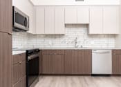 Thumbnail 35 of 52 - A kitchen with brown cabinets and a black oven.