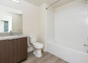Thumbnail 41 of 52 - A white toilet sits next to a sink in a bathroom.