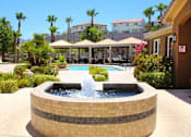 Thumbnail 18 of 39 - A fountain in the middle of a pool surrounded by a brick wall at Avalon at Seven Hills Apartments, Henderson, 91790