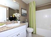 Thumbnail 36 of 123 - a bathroom with a green shower curtain and a sink and a toilet