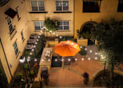 Thumbnail 94 of 112 - A patio with a table and chairs and an orange umbrella.