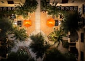 Thumbnail 95 of 112 - A view of a courtyard from above with plants and orange decorations.