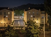 Thumbnail 97 of 112 - A residential area with two-story buildings and a street illuminated by streetlights.