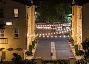 Thumbnail 101 of 112 - A street view of apartment buildings at night with lights on.