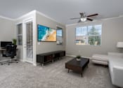 Thumbnail 12 of 112 - A living room with a flat screen TV mounted on the wall.