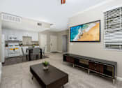 Thumbnail 13 of 112 - A modern living room with a kitchen in the background.