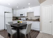Thumbnail 9 of 112 - A kitchen with white cabinets and a black table.