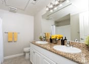 Thumbnail 18 of 112 - A bathroom with a granite countertop and white fixtures.