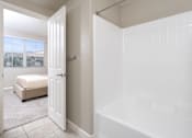 Thumbnail 15 of 112 - A white bathroom with a tub and a bed in the corner.