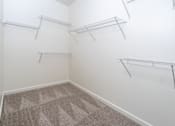Thumbnail 16 of 112 - A room with white walls and grey carpet has three metal racks on the wall.