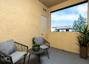 Thumbnail 20 of 112 - A balcony with a chair, table and potted plant.