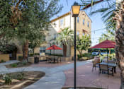 Thumbnail 86 of 112 - A sunny day at the outdoor seating area of a restaurant with tables and chairs.
