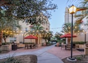 Thumbnail 91 of 112 - A patio area with tables and chairs is illuminated by string lights.