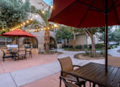 Thumbnail 87 of 112 - A patio with a table and chairs under a red umbrella.