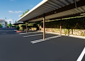 Thumbnail 81 of 123 - a parking lot with awning and vines on the side of a building