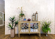 Thumbnail 10 of 123 - a wooden cabinet with glass doors with plants on top of it