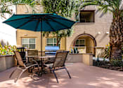 Thumbnail 56 of 123 - a patio with a table and chairs and an umbrella
