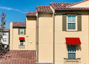Thumbnail 67 of 123 - Exterior of  apartment building with red awning over window at Paseos at Magnolia