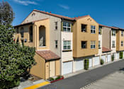 Thumbnail 64 of 123 - a row of yellow and white apartment buildings on the side of a street