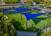 Thumbnail 36 of 57 - A blue shade structure is over a small soccer field.