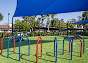 Thumbnail 38 of 57 - A playground with a blue canopy and red and blue play structures.