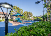 Thumbnail 43 of 57 - A playground with a blue slide and a green canopy.