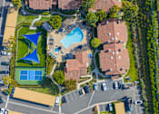 Thumbnail 45 of 57 - A bird's eye view of a residential area with a swimming pool and tennis court.