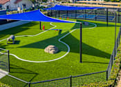 Thumbnail 46 of 57 - A small children's playground with a blue canopy.