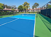 Thumbnail 49 of 57 - A tennis court with a blue surface and white lines.