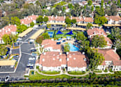 Thumbnail 51 of 57 - A bird's eye view of a residential area with houses, a swimming pool, and a parking lot.