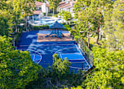 Thumbnail 57 of 57 - A basketball court surrounded by trees and a gazebo.