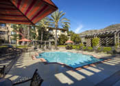 Thumbnail 2 of 25 - Pool with Lounge Seating, Umbrellas, and Tables at 55+ Remington at Ladera Ranch, California, 92694