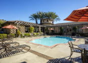 Thumbnail 3 of 25 - a swimming pool with lounge chairs and umbrellas in front of a hotel at 55+ Remington at Ladera Ranch, Ladera Ranch