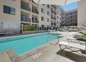 Thumbnail 7 of 26 - A pool area with a pool and sun loungers at Wilshire Valencia Apartment, California