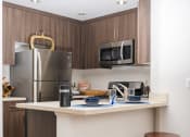 Thumbnail 19 of 59 - Kitchen Designed With Ample Storage Space at The Preston Miracle Mile Apartments, Los Angeles