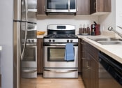 Thumbnail 18 of 59 - Fully Equipped Kitchen Includes Frost-Free Refrigerator, Electric Range, & Dishwasher at The Preston Miracle Mile Apartments, Los Angeles, CA, California