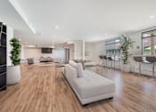 Thumbnail 16 of 26 - A modern living room with a white sofa and wooden floors at Wilshire Valencia Apartment, California, 90017