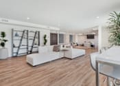 Thumbnail 15 of 26 - A white sofa set is placed in a room with wooden flooring at Wilshire Valencia Apartment, California