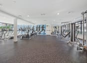 Thumbnail 11 of 26 - A gym with treadmills, elliptical machines, and other cardio equipment at Wilshire Valencia Apartment, Los Angeles, California