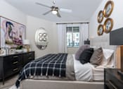 Thumbnail 7 of 39 - A bedroom with a bed, dresser, and a ceiling fan.