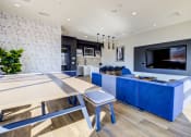Thumbnail 15 of 18 - a living room with a blue couch and a table and a television