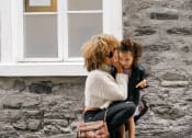 Thumbnail 60 of 83 - stylish mother and daughter whispering to each other outside at Bayswater Apartments, Burlingame