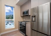 Thumbnail 76 of 117 - A modern kitchen with a stainless steel refrigerator and oven. at Skyview Sunset, California