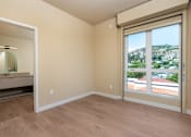 Thumbnail 97 of 117 - A room with a sliding glass door leading to a balcony with a view of the city. at Skyview Sunset, California