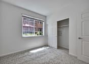 Thumbnail 40 of 40 - North San Jose, CA Apartments - Aviara - Unfurnished Bedroom with Carpeted Flooring, White Walls, Spacious Closet with Sliding Door, and Large Window.