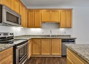 Thumbnail 35 of 40 - an empty kitchen with granite counter tops and wooden cabinets