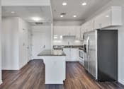 Thumbnail 24 of 40 - a renovated kitchen with white cabinets and stainless steel appliances