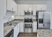 Thumbnail 27 of 40 - a kitchen with white cabinets and granite counter tops and stainless steel appliances