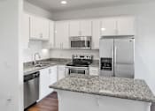 Thumbnail 29 of 40 - a kitchen with granite counter tops and stainless steel appliances