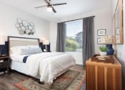 Thumbnail 6 of 36 - Bedroom with Large Window and Wood Style Floor at Montrachet Apartments, Napa